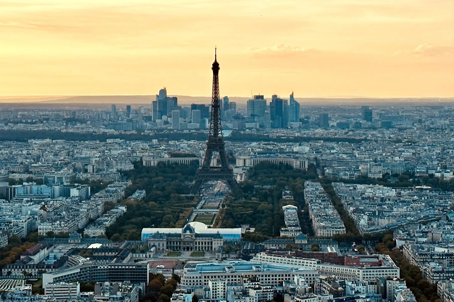 The Eiffel Tower in Paris silhouetted against a golden-hour sky