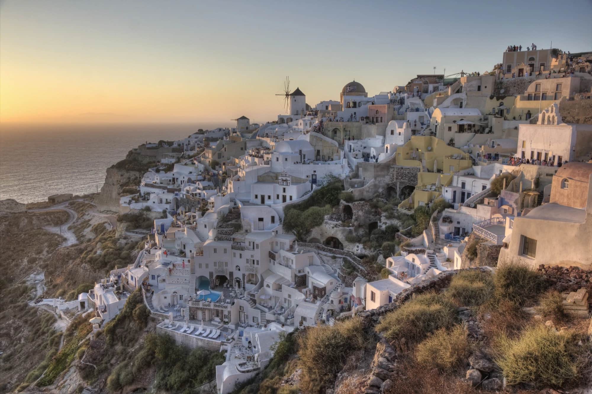 Whitewashed cliffside village of Oia overlooking the caldera in Santorini at sunset