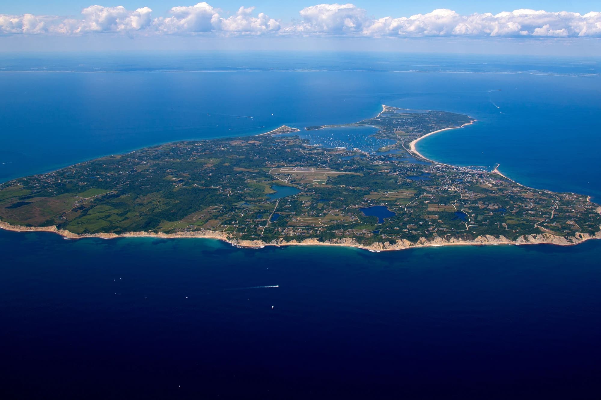 Aerial view of Block Island, Rhode Island, showing its coastline, harbors, and rolling green landscape