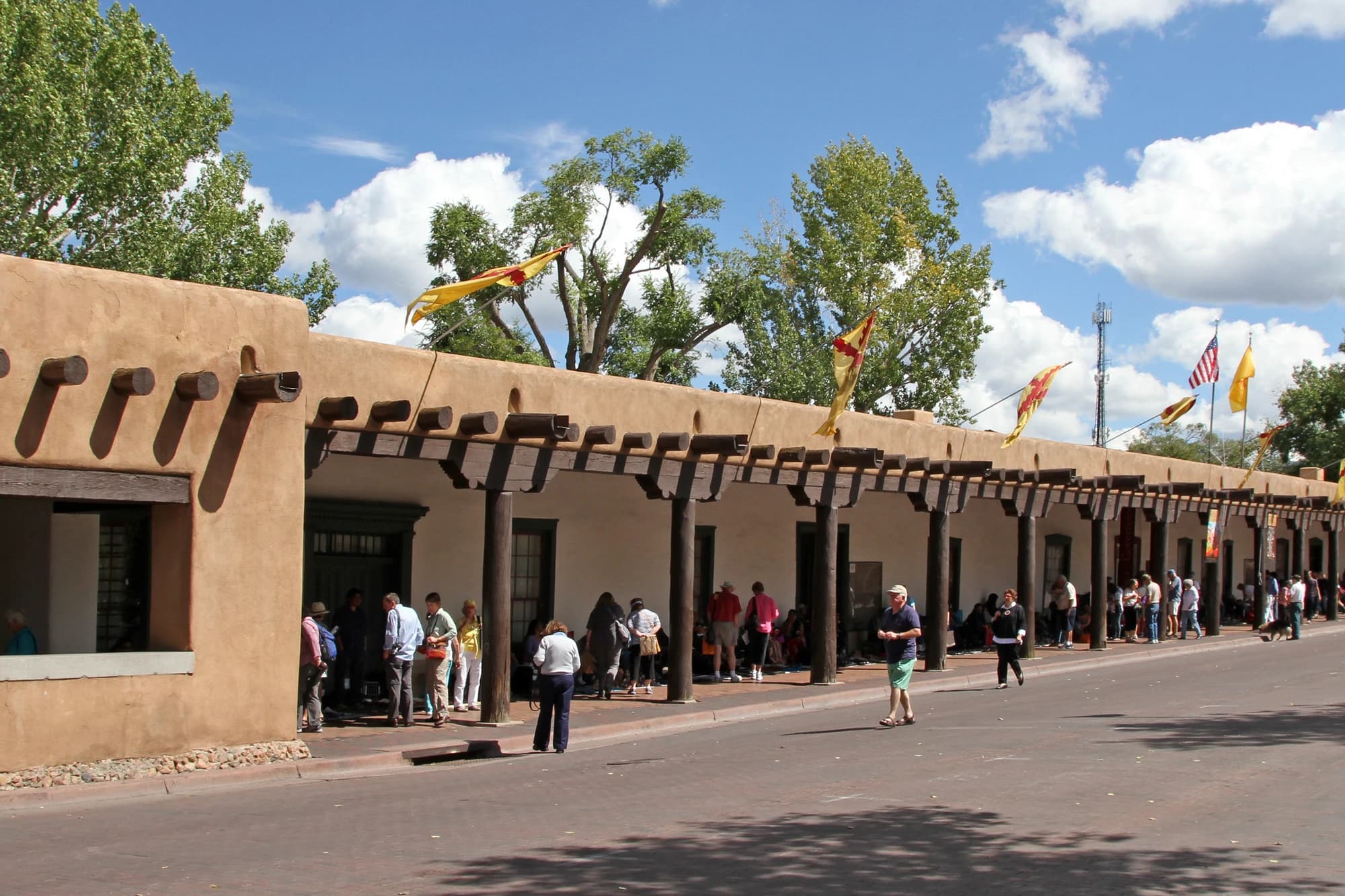 The historic adobe Palace of the Governors in downtown Santa Fe, with colorful flags lining its portal