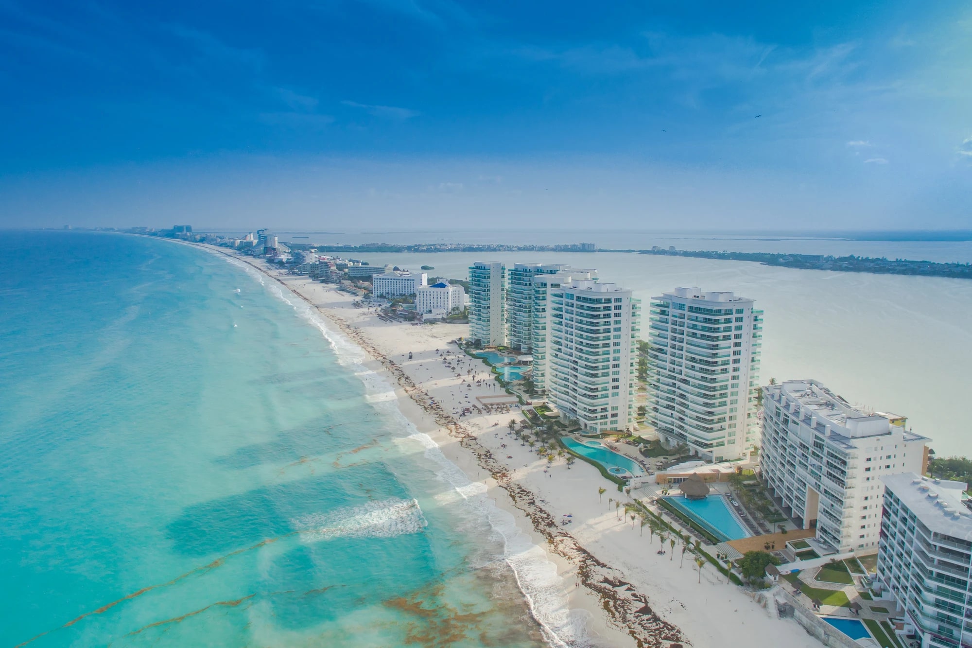 Aerial view of Cancún's Hotel Zone, a narrow strip of white sand and turquoise Caribbean water lined with beachfront resort towers