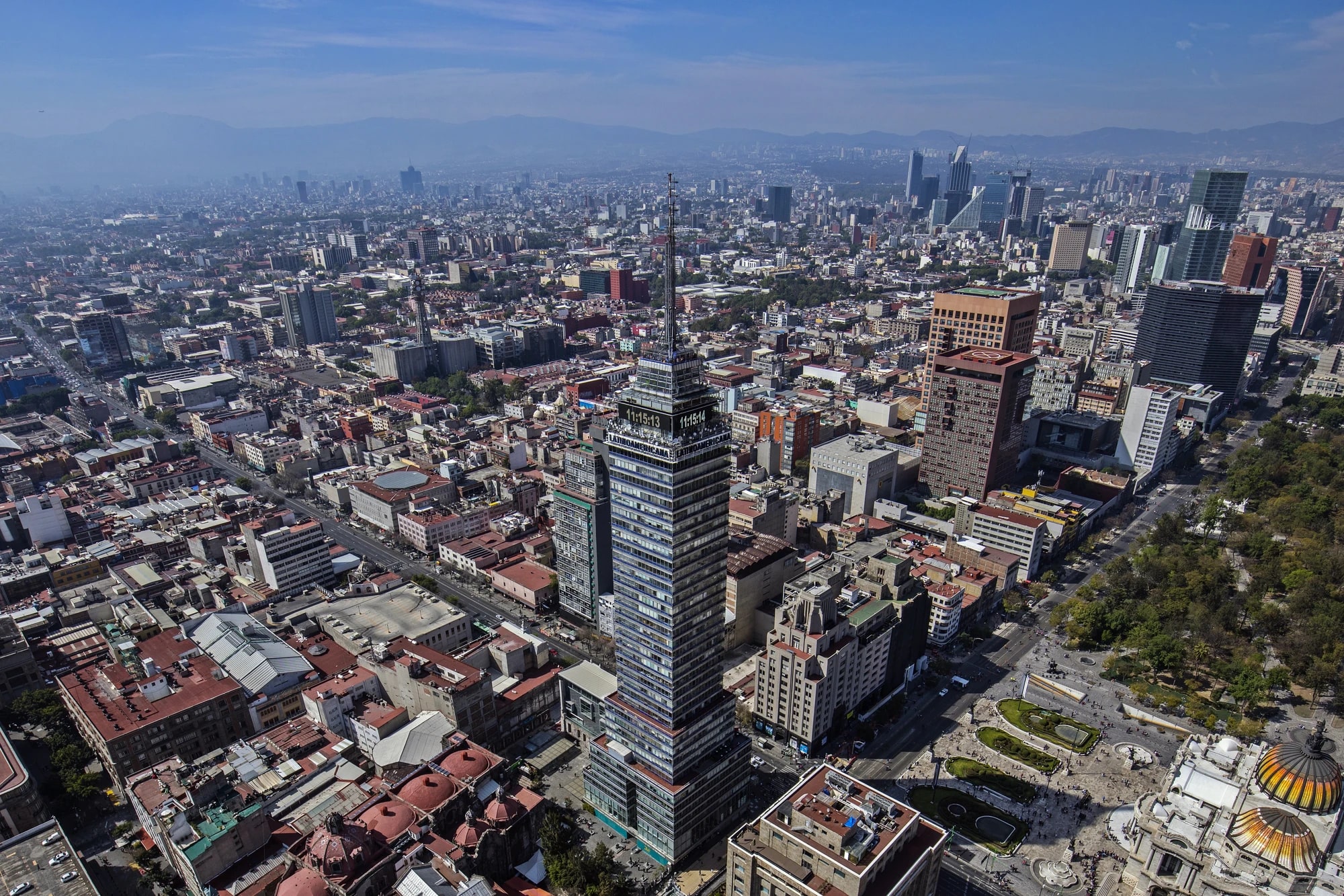 Aerial skyline of Mexico City with the Torre Latinoamericana rising above the dense downtown cityscape and distant mountains